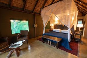 Schlafzimmer mit einem Bett mit Moskitonetz in der Unterkunft Parsons Hilltop Safari Camp in Balule Game Reserve