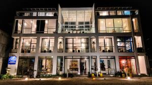 un gran edificio con muchas ventanas por la noche en Palassa Private Residences, en Boracay