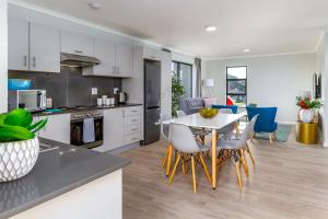 a kitchen and living room with a table and chairs at WINK Aparthotel Eaton Square in Cape Town