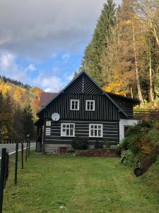 a black and white house with a yard at Roubenka Volský Důl in Špindlerův Mlýn