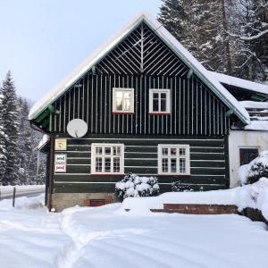 a black and white house in the snow at Roubenka Volský Důl in Špindlerův Mlýn
