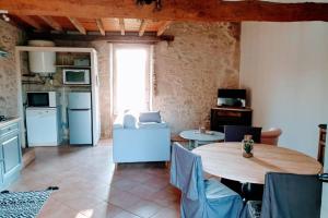 een woonkamer met een tafel en een keuken bij GITE AU COEUR DE LA CAMPAGNE in Saint-Sève