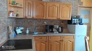 a kitchen with wooden cabinets and a white refrigerator at Agroturystyka Swojska Chata in Mrągowo