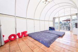 Habitación con cama con almohadas rojas en el suelo en 清境花鳥蟲鳴高山露營區, en Jen-chuang