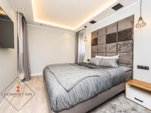 1 dormitorio con 1 cama y TV de pantalla plana en COMFORT INN APARTMENTS - Gdansk, Sadowa en Gdansk