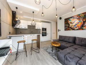 a kitchen and living room with a couch and chairs at COMFORT INN APARTMENTS - Gdansk, Sadowa in Gdańsk