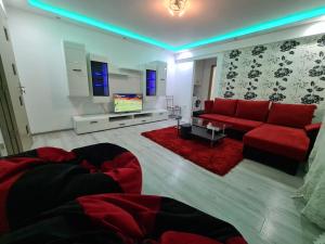 - un salon avec un canapé rouge et une télévision dans l'établissement Apartament ultra central 1, à Hunedoara