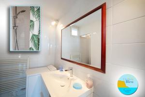 een witte badkamer met een wastafel en een spiegel bij HORIZON BLEU Vue Mer in Cassis