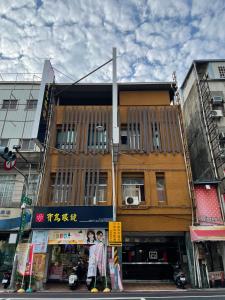 un edificio en una calle de la ciudad con gente parada frente a él en WE Hotel, en Miaoli