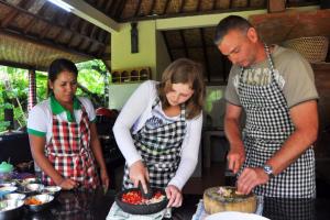 スミニャックにあるAryana Estate by Villas Direct Baliのキッチンに立って食事を準備している人々のグループ