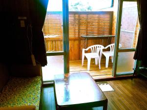 a porch with a table and chairs on a deck at Guest House Miyakojima in Miyako-jima