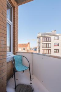 krzesło na balkonie z oknem w obiekcie Appartement Le Lavandou w mieście De Panne