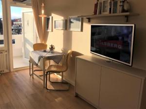 a living room with a tv and a table and a table and a dining room at Ferienwohnung Strandmarie, Haus Loreley, App. 14 in Sankt Peter-Ording