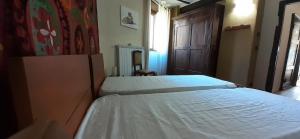 GaressioにあるAntico Conventoのベッドルーム1室(ベッド2台付)、木製のドアが備わります。