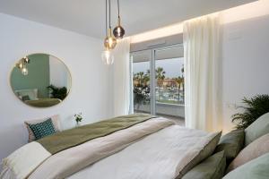 1 dormitorio con 1 cama grande y espejo en NEW & Modern Apartment - Marina, Sotogrande, en Sotogrande