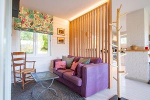 salon z fioletową kanapą i krzesłem w obiekcie Le Chalet w mieście Vresse-sur-Semois
