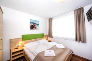 Schlafzimmer mit einem Bett mit einem grünen Kopfteil in der Unterkunft Apart Jasmin in Flachau