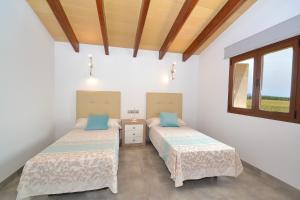 dwa łóżka w pokoju z oknem w obiekcie 178 Villa Flor de Sal ETV8491 by Mallorca Charme w mieście Muro +26 zdjęć
