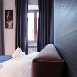 a bedroom with a bed with blue curtains and a window at Sogni D'Oro in Agrigento