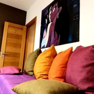 a bed with colorful pillows and a painting on the wall at Sogni D'Oro in Agrigento