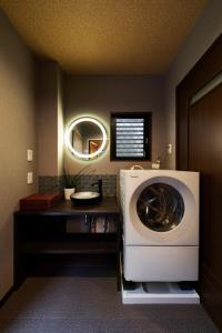 a washing machine in a bathroom with a mirror at Shirakabanoyado - AOARASHI 白樺の宿 - 青嵐, 3mins walk to station! in Osaka