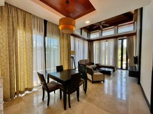 uma sala de estar com uma mesa de jantar e cadeiras em Home Sweet Villas, Karambunai em Kota Kinabalu