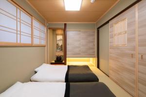 a bedroom with two beds and a sliding door at Shirakabanoyado - Seiran in Osaka