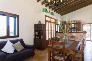 a living room with a table and a blue couch at Finca Son Rossignol 155 by Mallorca Charme in Sineu