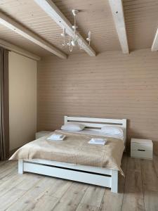 a bedroom with a bed in a room with wooden walls at Солодкий Гранат in Slavske