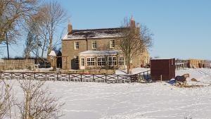 une grande maison dans la neige devant dans l'établissement Countryside Escape - The Night Owl, à Alnwick