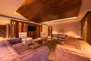 a living room with couches and a flat screen tv at Hometown Galleria Manipal in Manipala