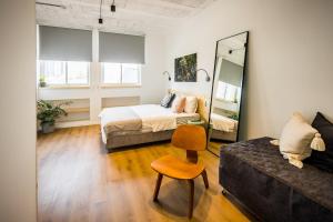 a bedroom with a bed and a couch and a mirror at Gia home in Tel Aviv