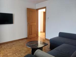 ein Wohnzimmer mit einem Sofa und einem Tisch in der Unterkunft Appartement "Casa Luigi" in Intragna