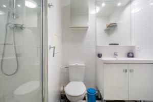 biała łazienka z toaletą i prysznicem w obiekcie studio tout confort près de Disney w mieście Serris