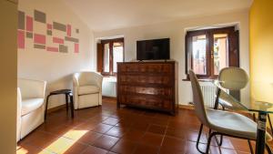 a living room with a tv and chairs and a table at Italianway - Castellana 68 in Udine