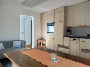 eine Küche und ein Wohnzimmer mit einem Tisch und einem Sofa in der Unterkunft Appartement "Casa Luigi" in Intragna