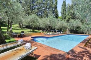 einen Pool in einem Garten mit einer Bank und Bäumen in der Unterkunft VIlla Merlo Ner0 in Florenz