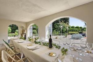 a dining room with a long table with white chairs at VIlla Merlo Ner0 in Florence