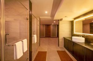 a bathroom with a glass shower and a sink at Hometown Galleria Manipal in Manipala +30 photos