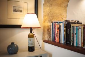 una lámpara en una mesa junto a un estante con libros en Casa Shelly Hospedería en Vejer de la Frontera