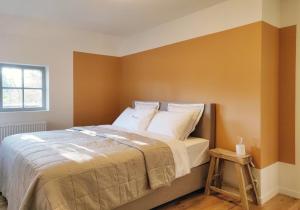 una camera da letto con un grande letto con pareti arancioni di forrest - Holiday Home - Vakantiewoning a Ronse