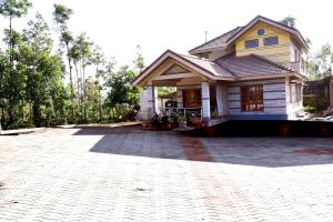 uma casa com uma entrada de tijolos em frente em Naturesky Homestay - Full Villa, Home Food & Coffee Estate em Chikmagalur