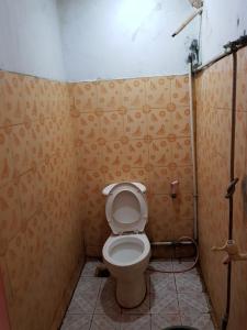 een kleine badkamer met een toilet in een kamer bij Hotel Alifah 1 Syariah in Rawabokor Dua