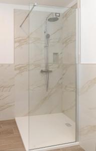 una doccia con porta in vetro in bagno di Hotel Da Si-Si a Gemona del Friuli