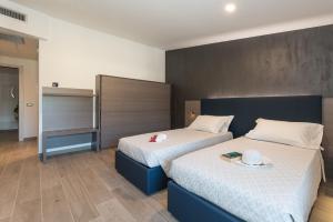 a bedroom with two beds and a large headboard at Hotel Da Si-Si in Gemona del Friuli