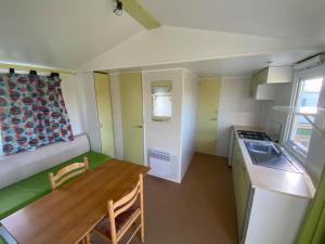 a small kitchen with a couch and a table in a room at Camping La Baie du Mont Saint Michel in Céaux