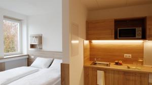 1 dormitorio con cama, fregadero y microondas en A2 Boarding House Memmingen, en Memmingen