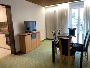 a room with a table and a television and chairs at Neptun 3 - im Zentrum von Bad Ragaz, mit kl. Balkon in Bad Ragaz