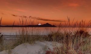a sunset over a body of water with a mountain at House Chrysoula Mitsokopi in Sarti