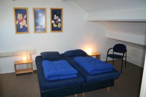 ein Schlafzimmer mit einem Bett mit blauen Laken und zwei Lampen in der Unterkunft Schorrebloem 1 in Nieuwvliet